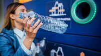Woman recycling plastic bottles in a machine