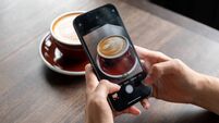 Hands woman using Iphone 13pro taking photo of a cup of latte in cafe for post in social media