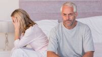 Frustated mature couple sulking after dispute on their bed