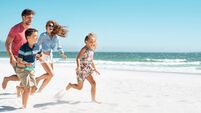 Happy family running on beach