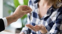 Young woman getting keys to new apartment from Real Estate Agent