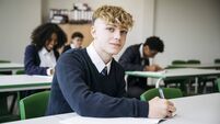 Portrait of British secondary schoolboy taking exam