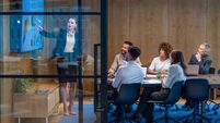Woman giving a big data presentation on a tv in a board room.