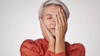 One mature woman suffering with a headache and looking stressed while posing against a grey copyspace background. Ageing woman e