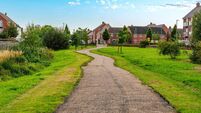 Sidewalk with nicely manicured landscape and brick houses in England