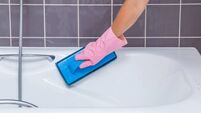 Hand washing tiles and bath with professional cleaning pad.