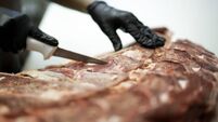 Female hands cutting a piece of ribs in a butchers shop