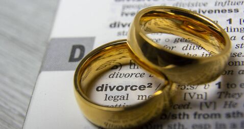 Divorce concept. Law and Justice background. Judge gavel on with two golden wedding rings