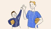 A young boy and adult man in blue shirts giving a high five while holding basketballs