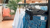 clothing and jeans on hangers in a store close up