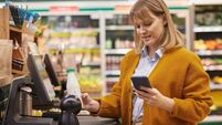Woman Scanning Groceries at Self Checkout in Supermarket