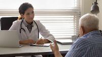 Female doctor therapist listening to patient complaints, filling form