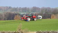 Tractor spraying slurry in a field on a winter day