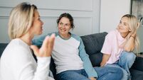 Three Girlfriends Chatting Happily While Sitting On The Couch At Home.