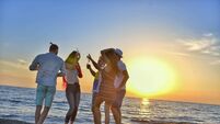 iStock-804291870.jpg group of happy young people dancing at the beach on beautiful summer sunset