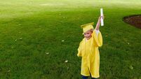 Boy graduating from preschool holds up his diploma
