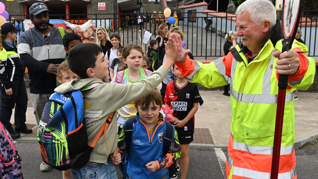<p>Lollipop man Ger Gleeson shares a cheery high-five with one of the children from Bunscoil Mhuire, Youghal, Co Cork, as he helps them safely cross the road. Ger has been named the Tonstix Lollipop Person of the Year 2025. Picture: Dan Linehan</p>