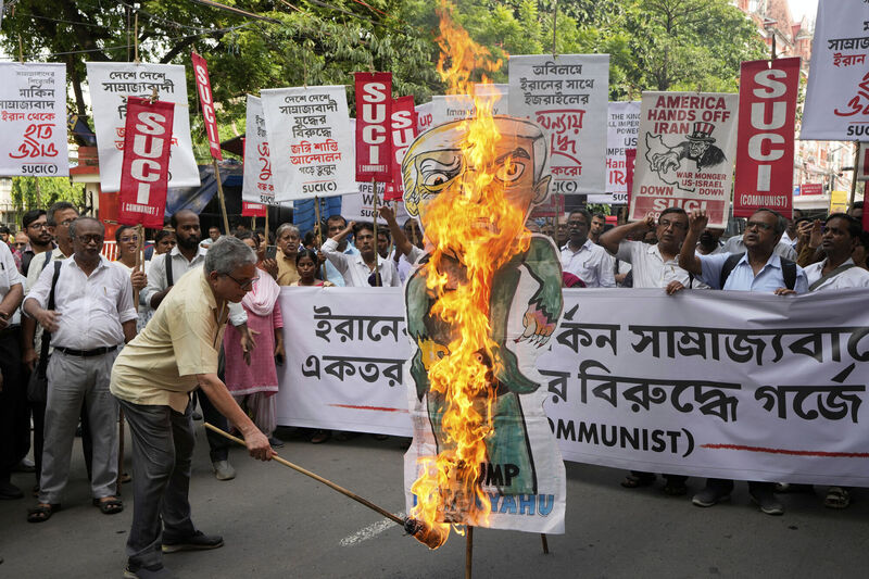 An activist of Socialist Unity Centre of India-Marxist burns a joint effigy of US President Donald Trump and Israeli Prime Minister Benjamin Netanyahu during a protest near the US Consulate, in Kolkata, India, Sunday, June 22, 2025. (AP Photo/Bikas Das) An activist of Socialist Unity Centre of India-Marxist burns a joint effigy of US President Donald Trump and Israeli Prime Minister Benjamin Netanyahu during a protest near the US Consulate, in Kolkata, India, Sunday, June 22, 2025. (AP Photo/Bikas Das)